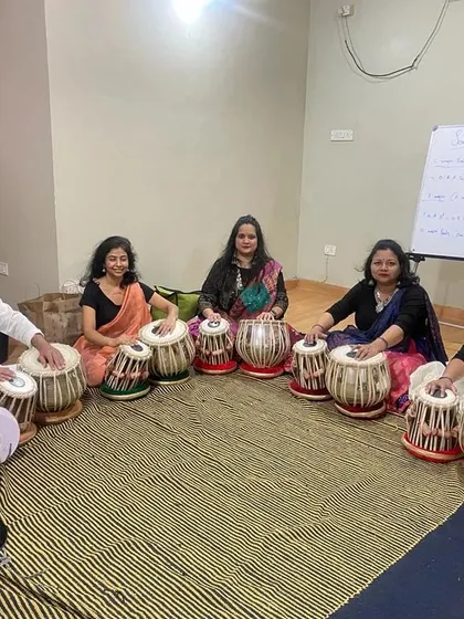We believe music is for everyone. Here, our adult students are deeply engaged in a group tabla class, demonstrating that it is never too late to learn a new skill and find your rhythm.
