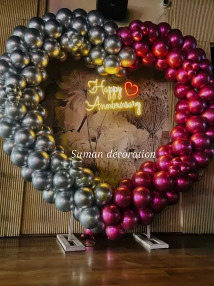 For anniversaries or romantic celebrations, I create these large, heart-shaped balloon arches. This one uses chrome silver and magenta balloons with a 'Happy Anniversary' neon sign in the center, making it a perfect backdrop for photos.