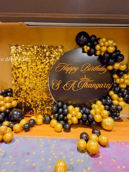 This was a grand 95th birthday celebration. I used a gold sequin shimmer wall for a glamorous photo backdrop, paired with a custom black circular sign. The black and gold balloon garland and light-up marquee number '95' complete this elegant party setup.