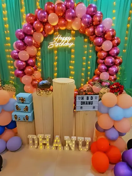 This full-circle balloon arch in bright pinks and oranges shows how I can transform the space with color. I also provide light-up letters to personalize the decor with a name.