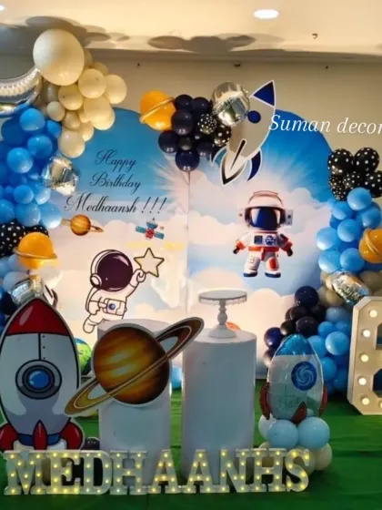 I design fun themes for kids' birthdays, like this outer space setup. It includes a galaxy-themed backdrop, character cutouts of astronauts and rockets, and a balloon garland. The marquee number '6' and the child's name in lights add a personal touch.