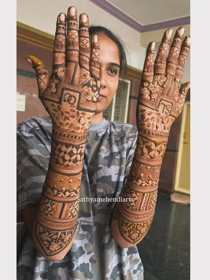 Love sealed in henna for this engagement ceremony. This design features interlocking rings and the couple's initials, "TS", surrounded by delicate floral patterns.