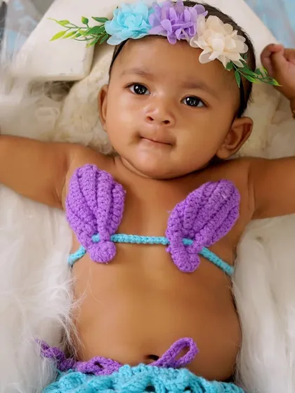 I love getting creative with themed baby photoshoots. For this little one, we created a magical mermaid theme. This close-up shot shows the adorable details, from the hand-crocheted mermaid costume to the floral headband, all while ensuring the baby is comfortable and safe.