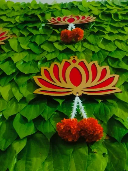 For this half saree function, I created a unique backdrop wall made entirely of fresh betel leaves. The vibrant green is accented with auspicious lotus cutouts and hanging marigold flowers, making it a beautiful and symbolic setting for the ceremony.