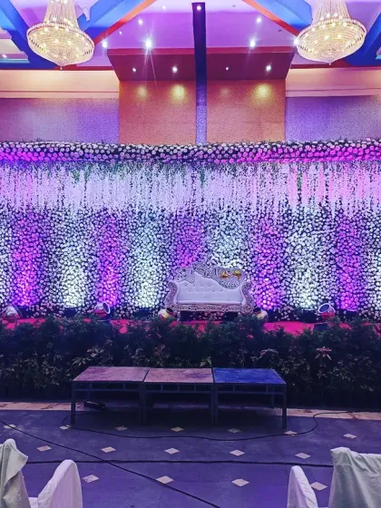 For a more elegant and formal conference, I created this beautiful stage using a curtain of white flowers. The purple uplighting added a touch of brand color and sophistication, transforming a simple hall into a professional and inviting space.