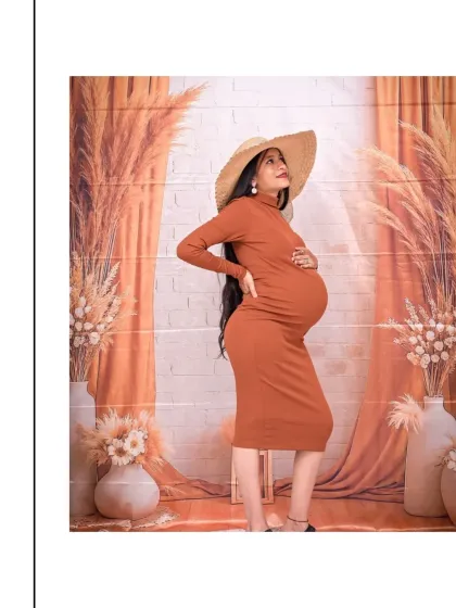 This profile shot is perfect for celebrating the beautiful silhouette of pregnancy. Set against our earthy, Boho-themed backdrop with pampas grass, the focus is entirely on the mom-to-be and her baby bump. The simple bodycon dress and straw hat add a touch of chic, modern style.