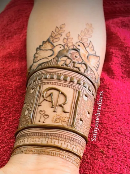 A beautiful example of an engagement design featuring the couple's initials, "AR", surrounded by love birds and delicate leafy patterns. It’s a sweet and symbolic start to their journey.