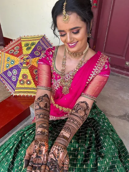 A closer look at the bride's hands, showing the detailed bride and groom figures on her palms.
