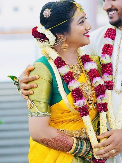 A heartwarming photo of the bride and groom. You can see a glimpse of her bridal mehendi on her arm as they share a happy moment together.