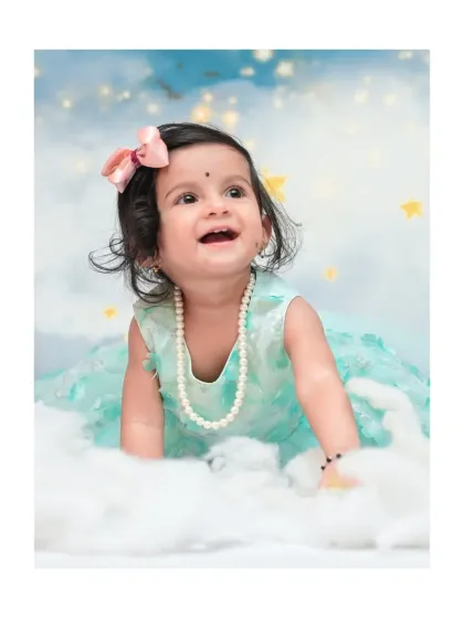 A close-up from a 'Moon & Stars' session, showing a beautiful, happy expression. I focus on capturing these sweet, fleeting moments of wonder against a dreamy, cloud-like backdrop.