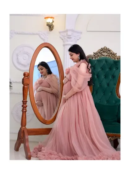 A moment of quiet reflection for the mom-to-be. Using props like this vintage-style mirror, I can create artistic and thoughtful portraits. This shot highlights one of our beautiful pink tulle gowns in a royal-themed setting, perfect for a classic and elegant maternity session.