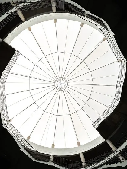 Looking up from the central courtyard of Mount Carmel School, the helical staircases spiral towards the skylight. This feature was designed to resemble a human DNA strand, creating a powerful visual metaphor for growth and connection at the heart of the school.