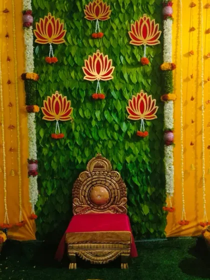 A unique backdrop I created for a half saree function using hundreds of fresh betel leaves. The vibrant green is complemented by yellow drapes, marigold garlands, and auspicious lotus motifs, making it a beautiful and traditional setting.